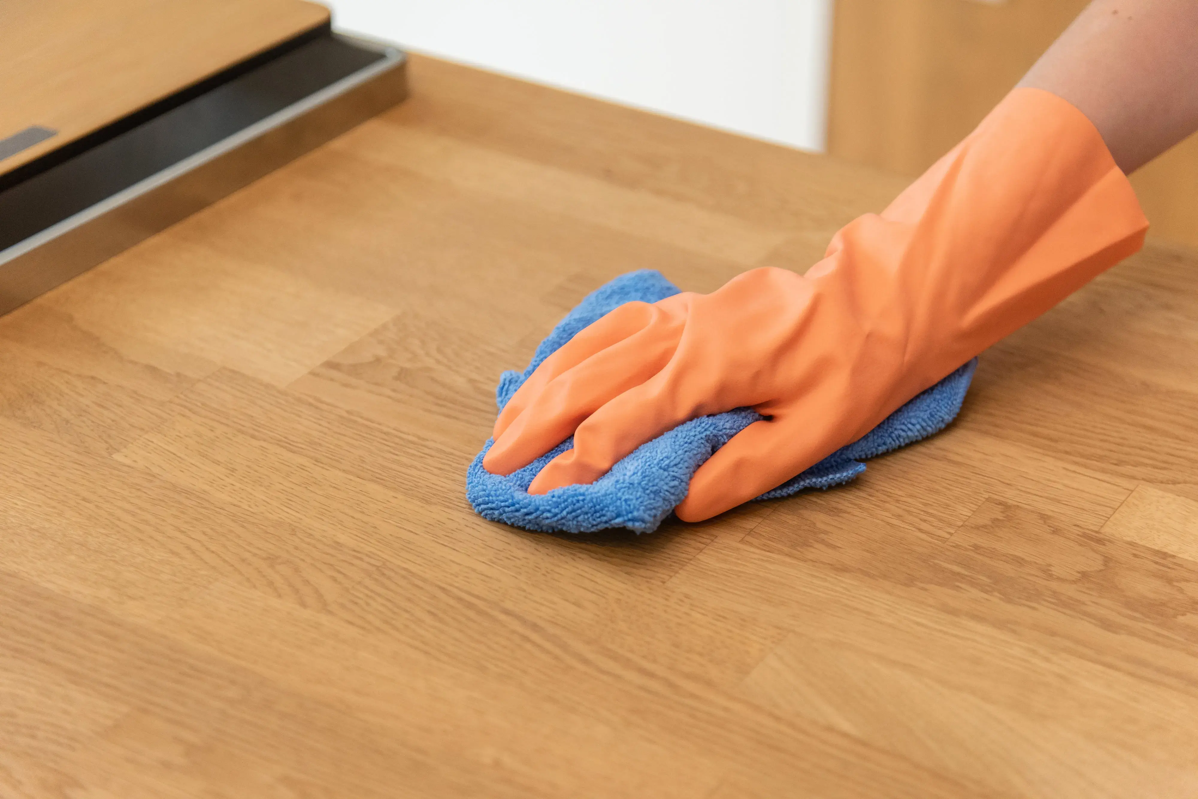 Massivholz-Arbeitsplatte abwischen mit Tuch und Gummihandschuhe